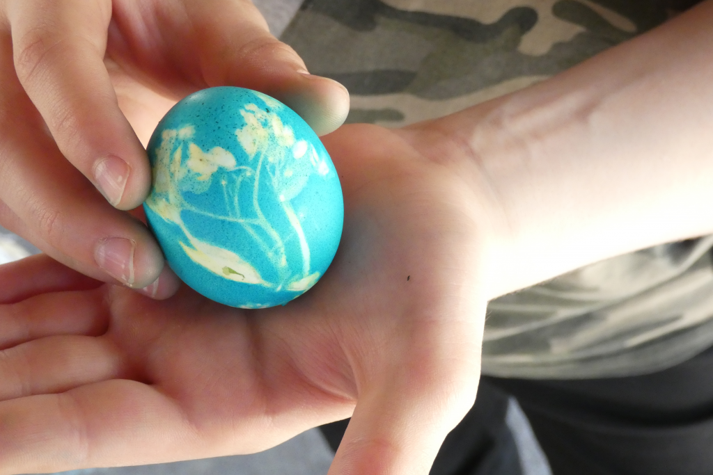 Foto Kinderhand hält bemaltes Ei